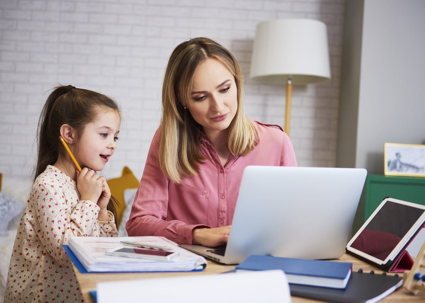 A parent and child looking through tutor profiles together on a laptop at home.